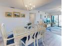 Bright dining area featuring a chandelier and seating for six with sliding door balcony access at 4175 S Atlantic Ave # 4110, New Smyrna Beach, FL 32169