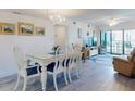 Bright dining area featuring a chandelier and seating for six with sliding door balcony access at 4175 S Atlantic Ave # 4110, New Smyrna Beach, FL 32169