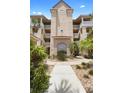 Inviting entrance with lush landscaping, a fountain, and classic architectural details with multiple stories at 438 Bouchelle Dr # 105, New Smyrna Beach, FL 32169