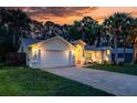 Beautiful home exterior illuminated at twilight, showcasing the garage, landscape, and elegant facade at 4623 Secret River Trl, Port Orange, FL 32129