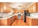Well lit kitchen with stainless steel appliances, wooden cabinets and laminate flooring at 5060 Audubon Ave, De Leon Springs, FL 32130