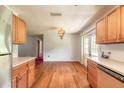 Bright kitchen featuring laminate floors and wooden cabinets, leading to backyard access at 5060 Audubon Ave, De Leon Springs, FL 32130