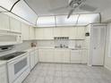 Well-lit kitchen features white cabinets, appliances, and a neutral tiled floor at 51 Fore Dr, New Smyrna Beach, FL 32168