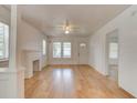 Bright living room featuring hardwood floors, white walls, a charming fireplace, and ample natural light at 514 Mary Ave, New Smyrna Beach, FL 32168