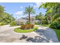 Elegant home exterior with a circular driveway, lush landscaping, and stately architecture at 6325 Palmas Bay Cir, Port Orange, FL 32127