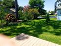 Lush backyard featuring mature trees, flowering plants, and a tranquil water view at 714 Fox Tail Ct, New Smyrna Beach, FL 32168