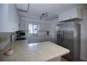 Bright kitchen with white cabinetry, stainless steel fridge, and a kitchen island at 805 E 18Th Ave, New Smyrna Beach, FL 32169