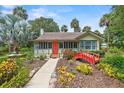 Inviting exterior showcasing a quaint home with a red bridge, lush landscaping, and charming architectural details at 807 Craig St, New Smyrna Beach, FL 32168