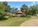 Charming home's exterior with mature landscaping and a circular gravel driveway at 807 Craig St, New Smyrna Beach, FL 32168