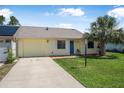 Inviting single-story house with a well-kept lawn and a sunny, yellow exterior at 837 Acorn Ln, Port Orange, FL 32127