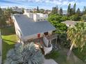 Exterior aerial showcasing this unique home's architectural details, deck, and beachside neighborhood at 895 Catfish Ave, New Smyrna Beach, FL 32169