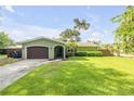 Charming single-Gathering home featuring a well-manicured lawn, attached garage, and inviting front entrance with a screen door at 154 Godfrey Rd, Edgewater, FL 32141
