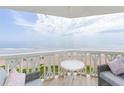 Comfortable seating and a small table are on an outdoor balcony with amazing views of the beach and ocean at 1051 Ocean Shore Blvd # 502, Ormond Beach, FL 32176