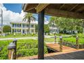View from the dock featuring a stately home with manicured lawn and lush landscaping at 1212 S Riverside Dr, New Smyrna Beach, FL 32168