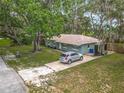 Aerial view of a charming home with a spacious yard, a driveway, and mature trees at 1331 Needle Palm Dr, Edgewater, FL 32132