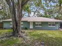 Charming single-story house with a well-manicured lawn and mature trees providing shade at 1331 Needle Palm Dr, Edgewater, FL 32132