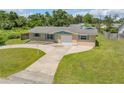 An eye-level view of the charming home featuring a well-maintained front yard and driveway at 2416 Pine Tree Dr, Edgewater, FL 32141