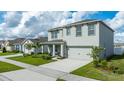 Two-story home featuring an attached two-car garage, well-maintained lawn, and front porch at 2667 Neverland Dr, New Smyrna Beach, FL 32168