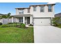 Two-story home featuring an attached two-car garage, well-maintained lawn, and front porch at 2667 Neverland Dr, New Smyrna Beach, FL 32168