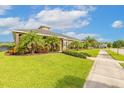 Beautifully landscaped front yard with palm trees and green grass in a single-story home at 2939 Bella Flore Ter, New Smyrna Beach, FL 32168