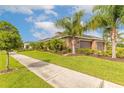 Side view of a three car garage with a beautifully landscaped yard and sidewalk in front at 2939 Bella Flore Ter, New Smyrna Beach, FL 32168