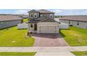Charming two-story home with a well-maintained lawn and brick driveway at 3116 Crab Trap Dr, New Smyrna Beach, FL 32168