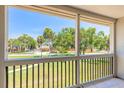 Relaxing view from a screened balcony overlooking a well-maintained lawn and mature trees at 3800 Saxon Dr # 180, New Smyrna Beach, FL 32169