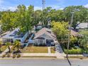 Property features a well-maintained yard, long driveway, mature trees, and a charming bungalow-style home at 402 N Orange St, New Smyrna Beach, FL 32168