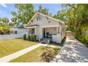 Charming bungalow with well-maintained lawn, inviting front porch, and neutral exterior paint at 402 N Orange St, New Smyrna Beach, FL 32168