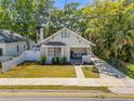 Charming bungalow with well-maintained lawn, inviting front porch, and neutral exterior paint at 402 N Orange St, New Smyrna Beach, FL 32168