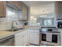 Modern kitchen features stainless steel appliances and stylish backsplash at 4155 S Atlantic Ave # 111, New Smyrna Beach, FL 32169