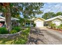 Well-maintained single-story home with a green roof, lovely landscaping, and a paved driveway at 5146 Pineland Ave, Port Orange, FL 32127