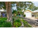 Inviting home with lush front lawn, garden beds, and two blue chairs on the porch at 5146 Pineland Ave, Port Orange, FL 32127