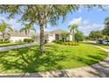 Expansive front lawn featuring lush green grass, mature trees, and landscaping that enhances curb appeal at 5849 Ansley Way, Mount Dora, FL 32757