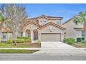 Two-story house with beige exterior, two-car garage, and landscaping at 5244 Oakbourne Ave, Davenport, FL 33837