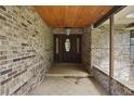 Inviting covered entryway with brick accents, tile flooring, and a stately front door at 10290 Buck Rd, Orlando, FL 32817