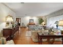Cozy living room with hardwood floors, floral print furniture, and natural light at 10290 Buck Rd, Orlando, FL 32817
