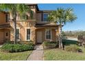 Tan two-story townhome with palm trees, brick walkway, and neatly landscaped yard at 3204 Calabria Ave # 443, Davenport, FL 33897