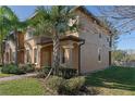 Side view of tan two-story townhome showcasing its architectural details and landscaping at 3204 Calabria Ave # 443, Davenport, FL 33897