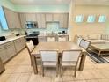 Eat-in kitchen showcasing stainless appliances, plenty of cabinets and a wooden dining table at 3001 Sea Plane Ln, Kissimmee, FL 34747