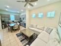 Open concept living room showcasing a view to the modern kitchen and dining area with stainless appliances at 3001 Sea Plane Ln, Kissimmee, FL 34747