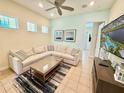 Bright living room featuring a comfortable sectional sofa, stylish rug, and neutral decor at 3001 Sea Plane Ln, Kissimmee, FL 34747