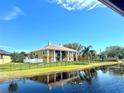 Stately two-story home with a manicured lawn, black fence, and waterfront views at 10843 Lakeshore Dr, Clermont, FL 34711