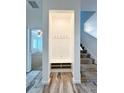 Entryway niche with storage shelves, hooks, and wood-look tile flooring at 224 Trinity Ridge Cir, Davenport, FL 33897