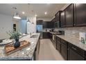 Modern kitchen featuring dark cabinets, stainless steel appliances, and granite countertops at 4189 Lana Ave, Davenport, FL 33897