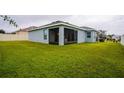 Spacious backyard with grassy lawn and screened-in patio at 1080 Condor Dr, Haines City, FL 33844
