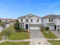 Two-story house with a paved driveway and landscaping; other homes visible at 1539 Flange Dr, Davenport, FL 33896