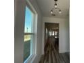 Elegant hallway with wood flooring and light fixtures leading to a spacious living area at 14046 Scarlet Aster Aly, Winter Garden, FL 34787