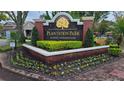 Landscaped entrance sign for Plantation Park Luxury Condominiums with vibrant flower beds and manicured greenery at 13103 Mulberry Park Dr # 824, Orlando, FL 32821