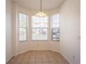 Bright dining area with a pendant light fixture, tile flooring, and bay windows at 4712 Hemingway House St, Kissimmee, FL 34746